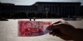 a person holding a piece of paper with a picture of a building in the background