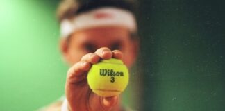 person holding green Wilson tennis ball