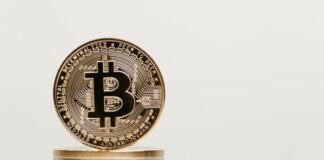 a stack of coins with a bit coin on top