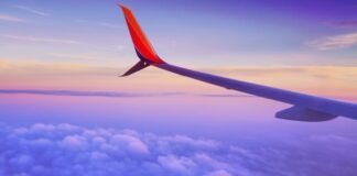 person in a plane flying at high altitude taking photo of left airplane wing during daytime