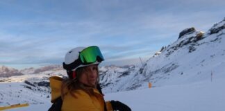 a person with a backpack and skis standing in the snow