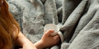 woman holding white ceramic mug