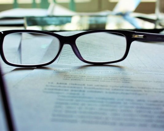 black-framed eyeglasses on white printing paper
