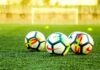 The Evolution of Football: From Ancient Origins to Modern Phenomenon three white-and-black soccer balls on field