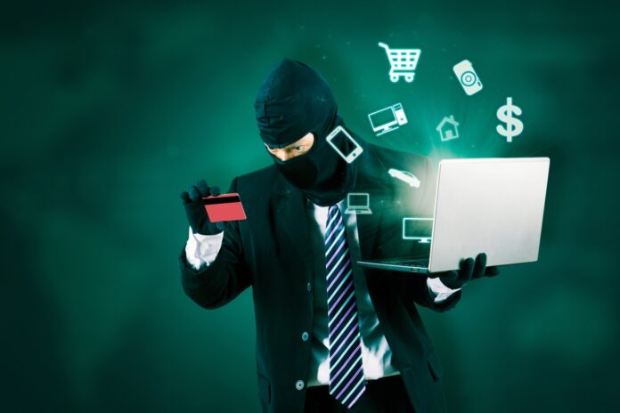 Internet,Theft,-,Hacker,Wearing,A,Mask,And,Holding,A