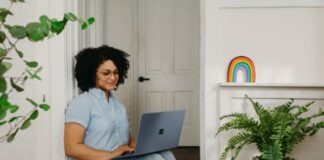 a woman sitting on the floor using a laptop