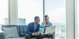 two men in suit sitting on sofa