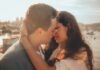 man and woman kissing beside bay