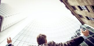 low-angle photography of man in the middle of buidligns