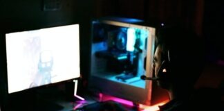 a person wearing a mask sitting in front of a computer