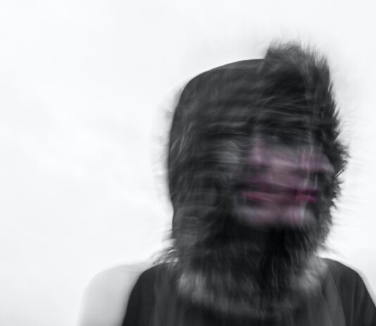 Creepy blurred photo of a person's face and a furry hood