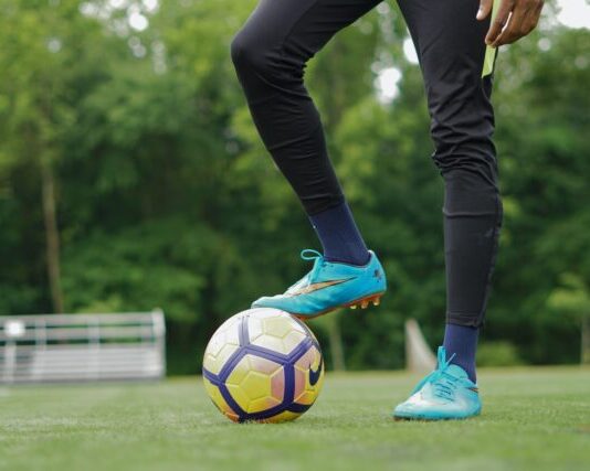 person in blue nike soccer shoes and black pants