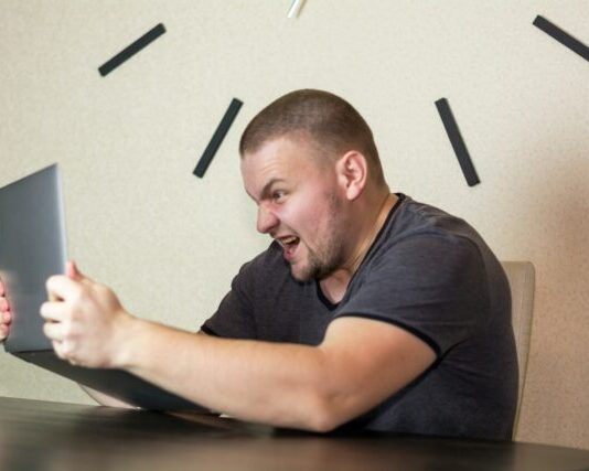 a man sitting in front of a laptop computer
