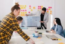 Mann steht hinter einem Flachbildschirm