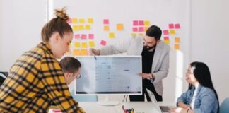 man standing behind flat screen computer monitor