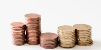 stacked round gold-colored coins on white surface