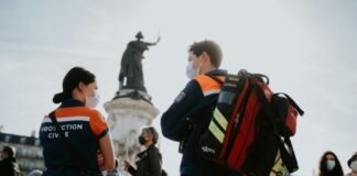 man in black and orange jacket carrying black and red backpack