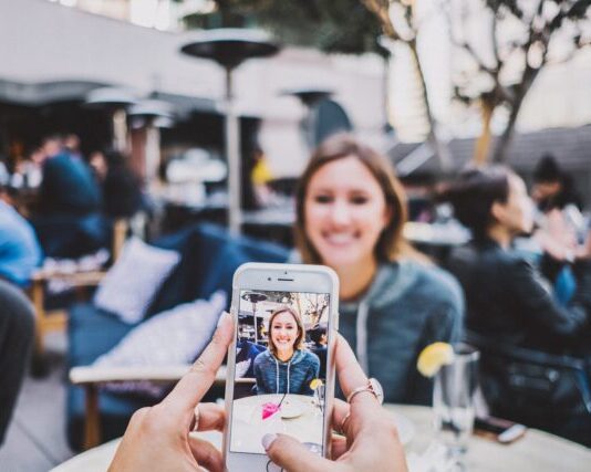 person taking photo of woman