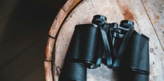 black binoculars on brown wooden table
