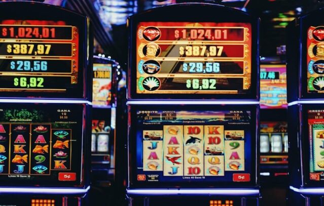 Photo by Nathana Rebouças a row of slot machines sitting next to each other