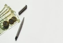 Common Misconceptions About Compound Interest gray pen beside coins on Indian rupee banknotes