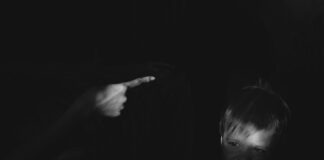 grayscale photo of girl holding her chin