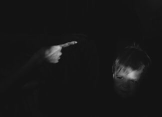 grayscale photo of girl holding her chin