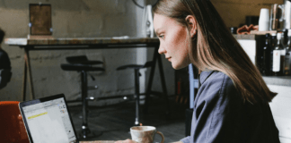 A person sitting at a table using a computer Description automatically generated