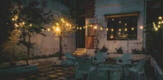 a patio with a table, chairs and lights