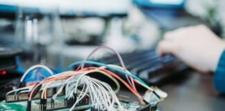 person using computer keyboard near green circuit board