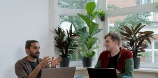 man in red and black crew neck t-shirt using silver macbook