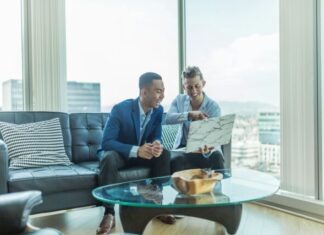 two men in suit sitting on sofa