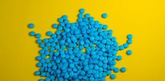 a pile of blue pills on a yellow background