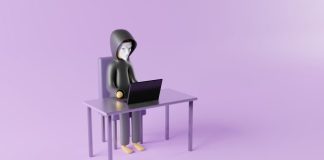 a person sitting at a desk with a laptop on it