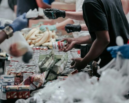 man in black t-shirt holding coca cola bottle