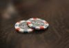two poker chips sitting on top of a wooden table