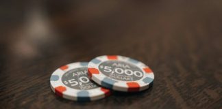 two poker chips sitting on top of a wooden table