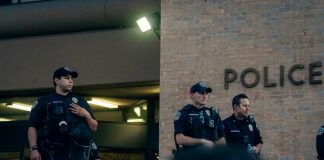 man in black and white uniform standing near woman in black jacket