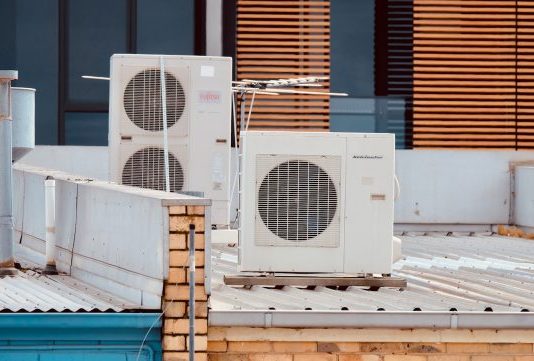white and gray box fan on brown wooden table