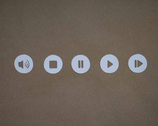 a set of four white buttons on a brown surface