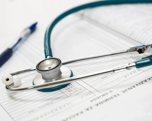 A stethoscope on top of a medical form AI-generated content may be incorrect.