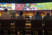 The Rise of Social Betting and Live Gaming: Trends Transforming Singapore’s Digital Scene a group of people sitting at a bar watching tv