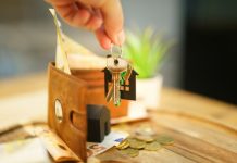 The Most Important Keys to Success as a New Landlord Hand holding keys with house charm and wallet.