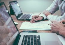 Revenue Management KPIs – How Core PMS Functions Drive RevPAR Optimization person holding pencil near laptop computer