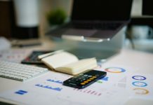 Smart Ways to Keep Your Business Spending Under Control a remote control sitting on top of a table next to a book