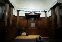 an empty courtroom with wooden paneling and columns