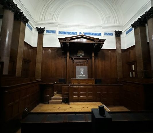 an empty courtroom with wooden paneling and columns