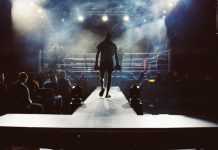 From Amateur Glory to Professional Reality: Career Transitions in Pakistani Boxing man standing and walking going on boxing ring surrounded with people