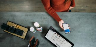 person holding smartphone beside tablet computer