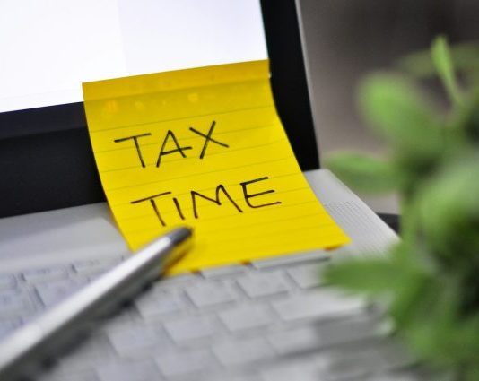 Yellow sticky note with tax time written on it.